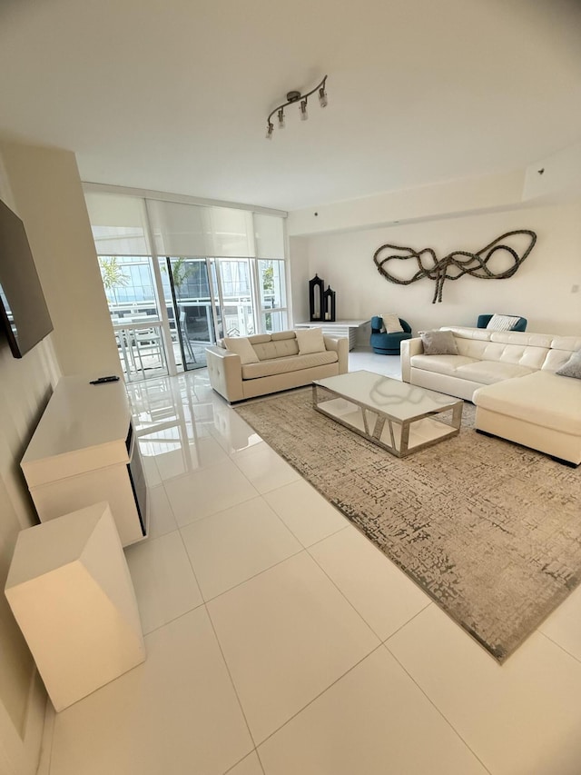 tiled living area featuring a wall of windows and rail lighting