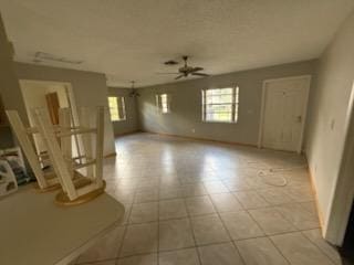 unfurnished living room featuring ceiling fan and baseboards