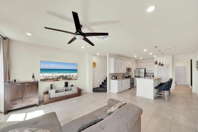 living area with light tile patterned floors, recessed lighting, visible vents, and ceiling fan