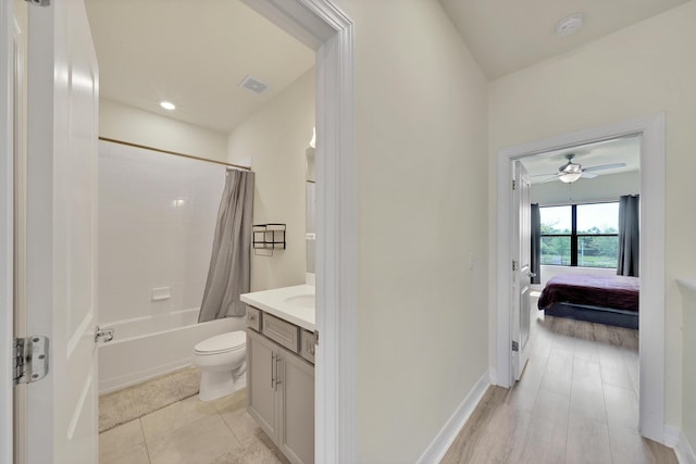 full bathroom with visible vents, baseboards, toilet, shower / tub combo with curtain, and vanity