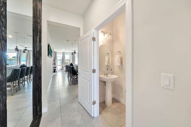 corridor with light tile patterned floors and baseboards