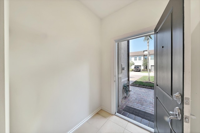 foyer entrance featuring light tile patterned floors and baseboards