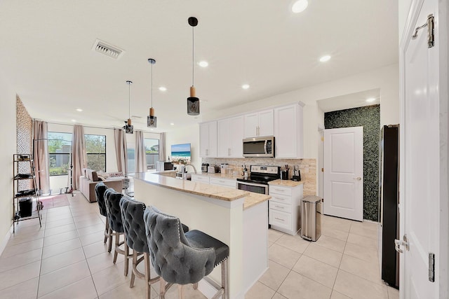 kitchen featuring tasteful backsplash, light tile patterned floors, visible vents, and stainless steel appliances