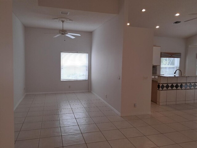 unfurnished room featuring ceiling fan, light tile patterned floors, a wealth of natural light, and recessed lighting