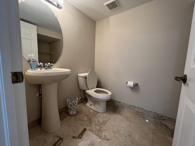 bathroom featuring toilet, baseboards, visible vents, and a sink