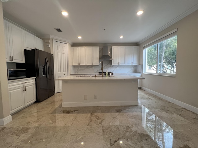 kitchen with marble finish floor, wall chimney exhaust hood, stainless steel microwave, and visible vents