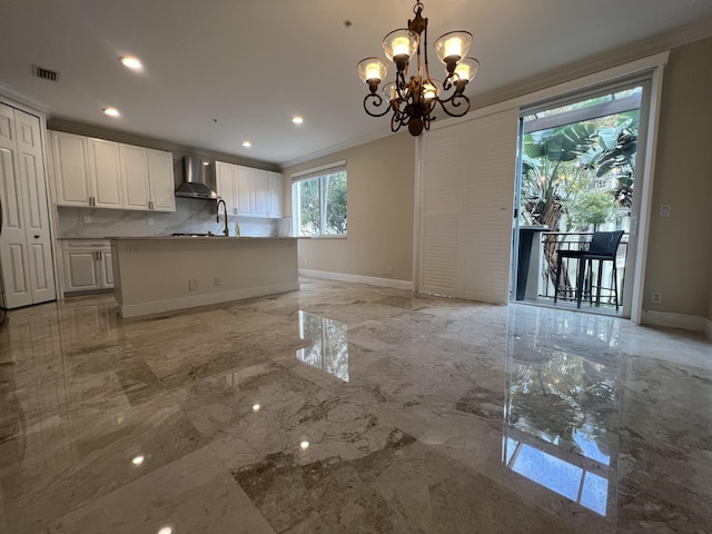 kitchen featuring marble finish floor, wall chimney range hood, visible vents, and crown molding