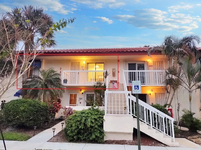 view of front of property featuring stairs, a porch, and stucco siding