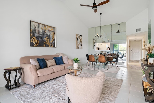 tiled living area featuring high vaulted ceiling, visible vents, and ceiling fan with notable chandelier