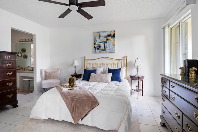 bedroom with a textured ceiling, ceiling fan, light tile patterned flooring, and ensuite bath