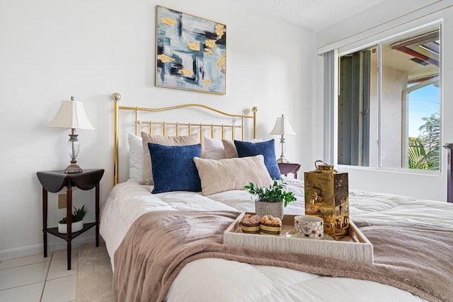 bedroom with a textured ceiling, tile patterned flooring, and baseboards