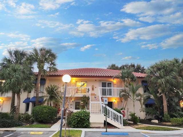 view of property featuring stairs and uncovered parking