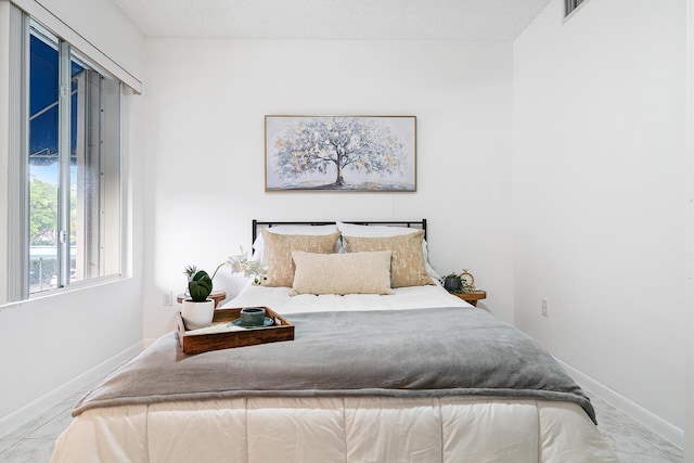 bedroom with a textured ceiling and baseboards