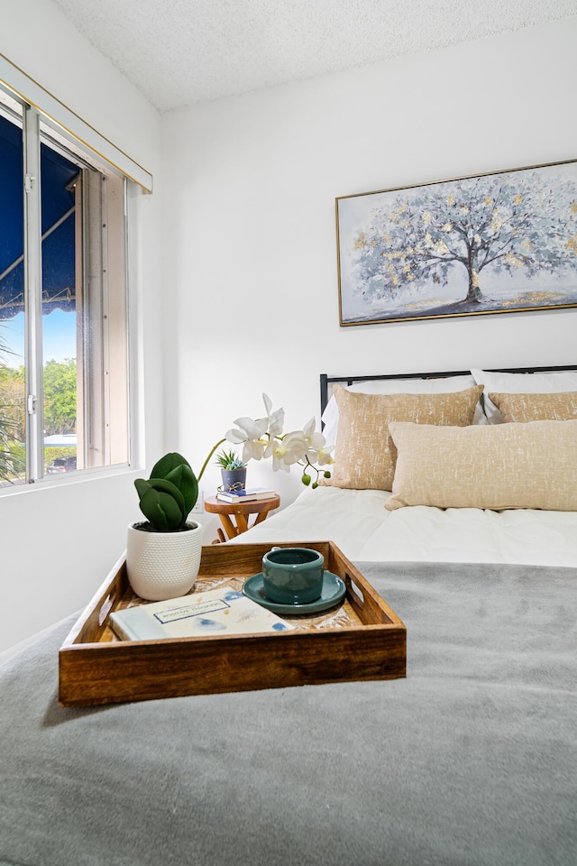 bedroom featuring a textured ceiling, carpet flooring, and baseboards