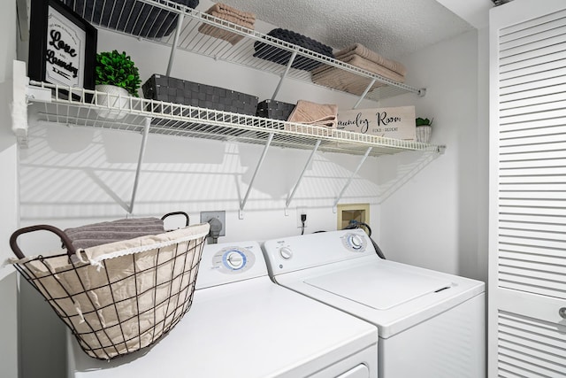 laundry area with laundry area, a textured ceiling, and washer and dryer