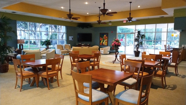 dining room featuring light carpet, a tray ceiling, and recessed lighting