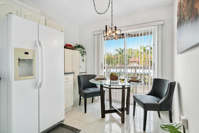 dining area with a notable chandelier, a textured ceiling, and light tile patterned floors