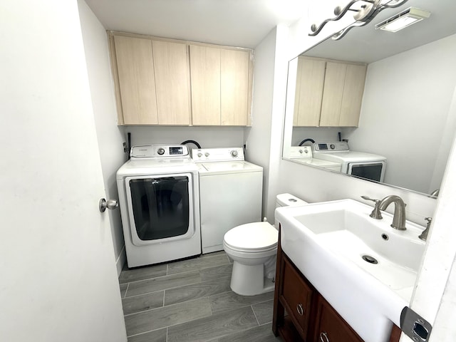 laundry area featuring visible vents, wood finish floors, laundry area, a sink, and washer and dryer