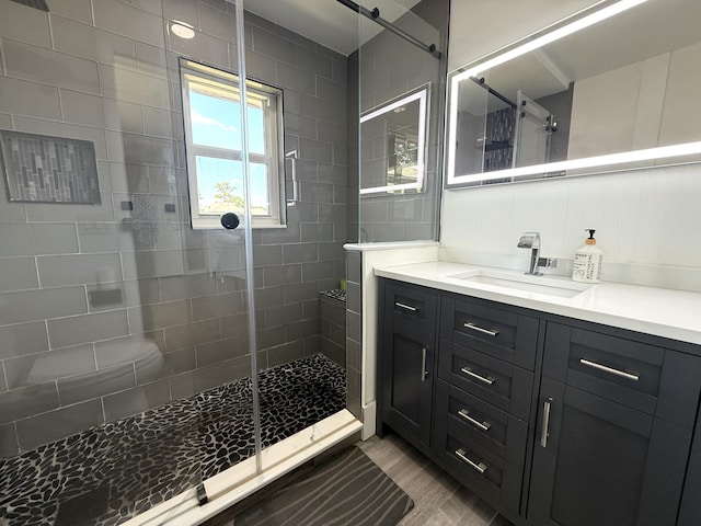 full bathroom featuring vanity, wood finished floors, and a shower stall