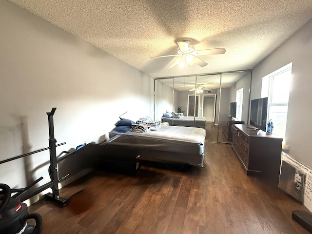 bedroom with ceiling fan, a closet, a textured ceiling, and dark wood finished floors