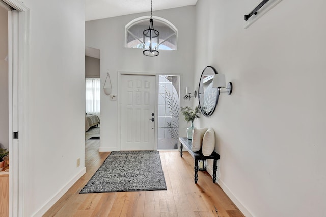 entrance foyer featuring light wood-style floors, a high ceiling, and baseboards