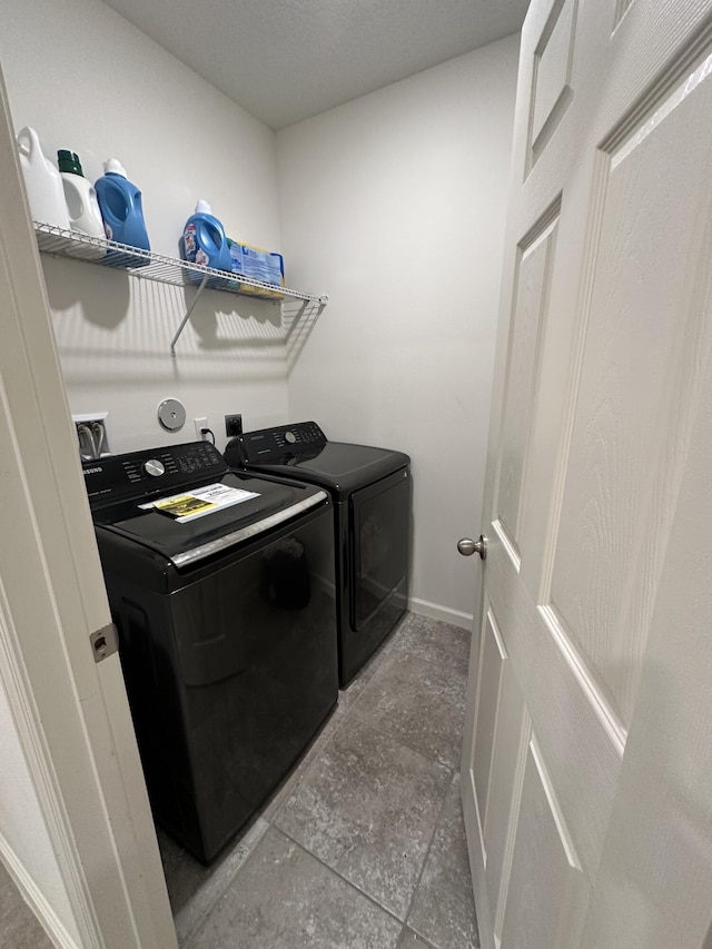 washroom featuring washer and clothes dryer, laundry area, and baseboards