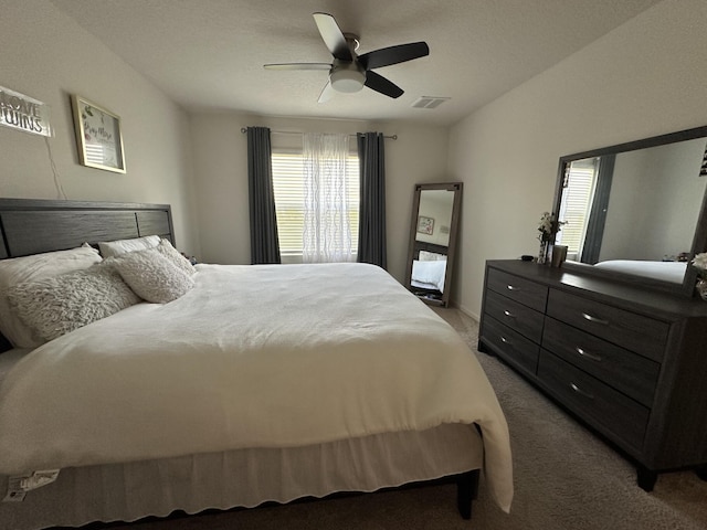 bedroom featuring visible vents, ceiling fan, and light carpet