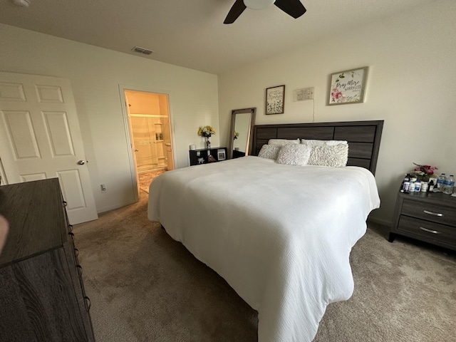 carpeted bedroom with ensuite bath, visible vents, and a ceiling fan