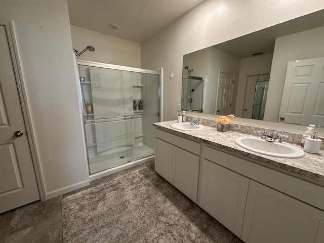 bathroom with visible vents, a sink, a shower stall, and double vanity