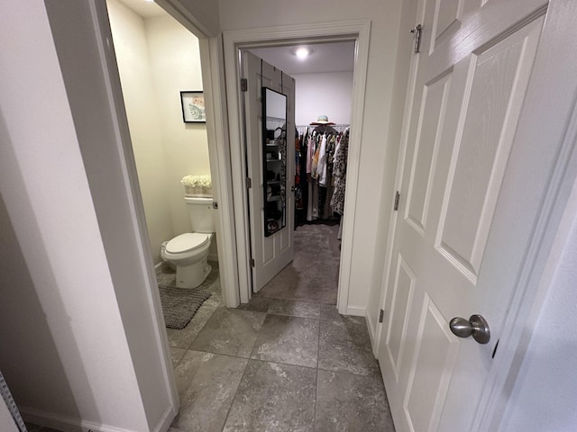 bathroom with toilet and baseboards