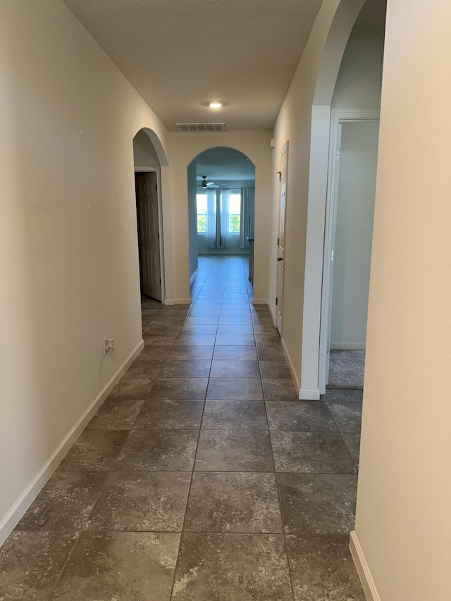 hall with arched walkways and baseboards