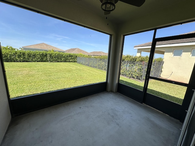 unfurnished sunroom featuring ceiling fan