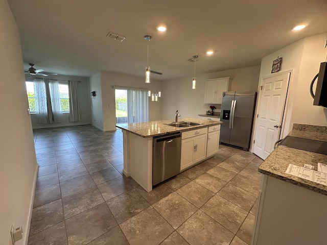 kitchen with a kitchen island with sink, black appliances, a sink, white cabinetry, and open floor plan