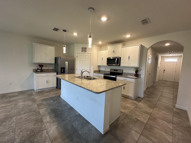 kitchen featuring arched walkways, appliances with stainless steel finishes, a sink, baseboards, and visible vents