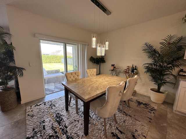 dining area featuring a notable chandelier and baseboards