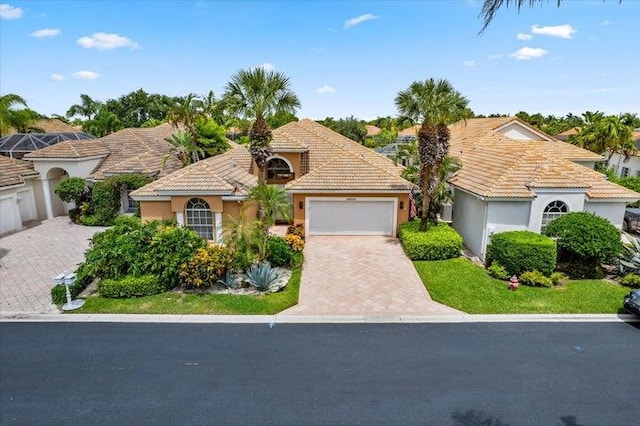 view of front facade with a garage, a tiled roof, decorative driveway, and stucco siding