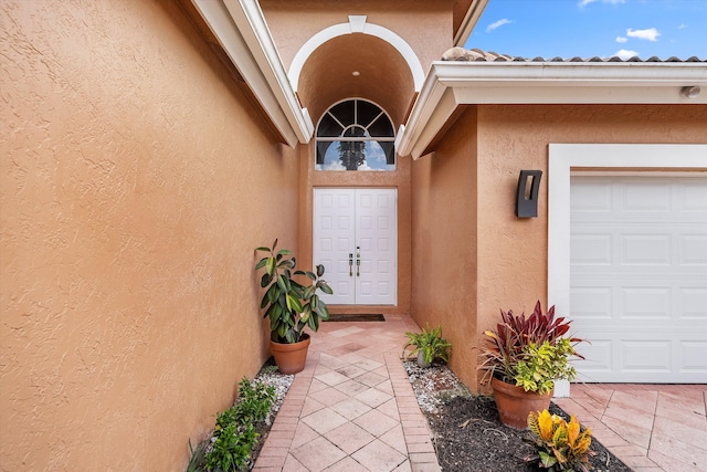 10786 Greenbriar Villa Dr, Lake Worth, FL 33449 - doorway to property featuring a garage and stucco siding