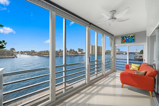 sunroom featuring a water view and ceiling fan