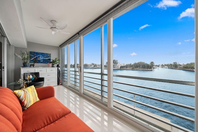 sunroom / solarium featuring a ceiling fan and a water view