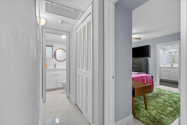 hallway featuring baseboards and visible vents