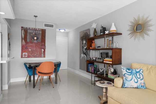 dining space with visible vents, a textured ceiling, and baseboards