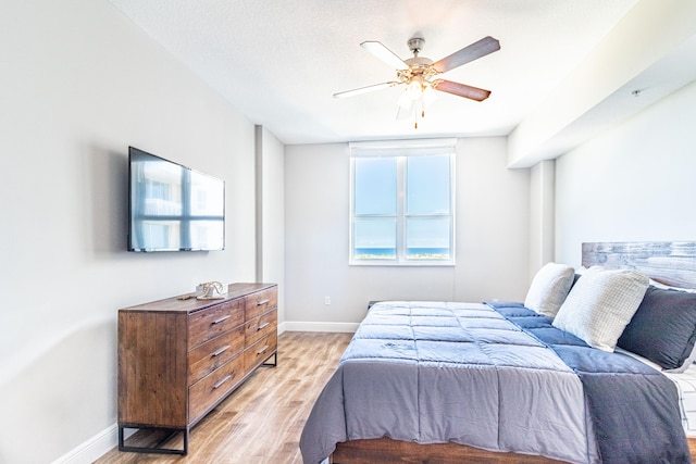 bedroom featuring a ceiling fan, light wood-type flooring, and baseboards