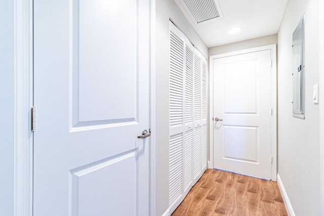 corridor featuring visible vents, light wood-style flooring, and baseboards