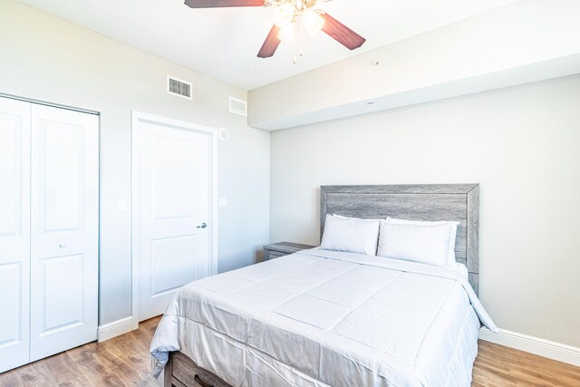 bedroom featuring visible vents, baseboards, a closet, and wood finished floors