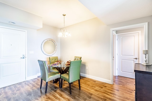 dining area with a notable chandelier, baseboards, and wood finished floors