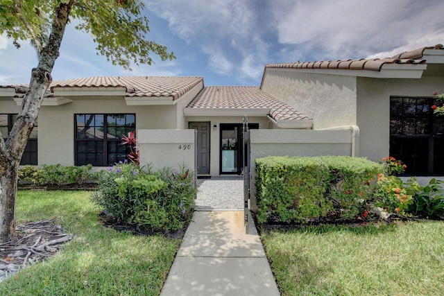 doorway to property with a tile roof and stucco siding