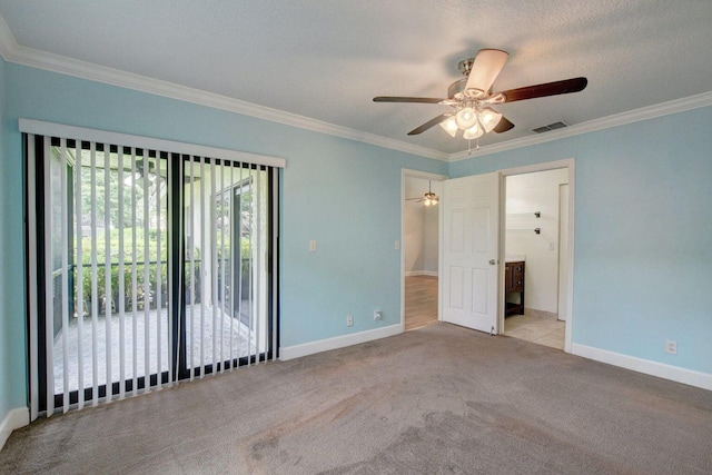 carpeted spare room featuring visible vents, ornamental molding, a ceiling fan, a textured ceiling, and baseboards