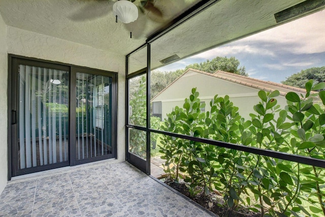 unfurnished sunroom featuring a ceiling fan