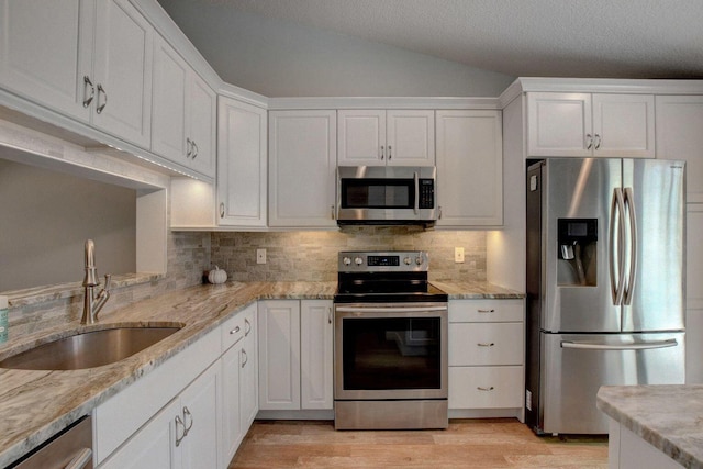 kitchen featuring tasteful backsplash, appliances with stainless steel finishes, a sink, and white cabinets