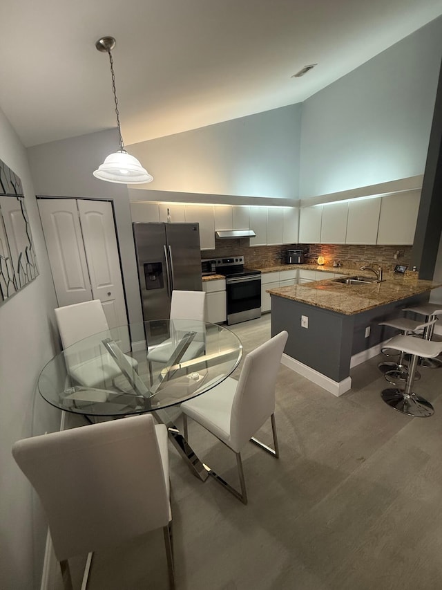 dining space featuring high vaulted ceiling, light wood-style flooring, and visible vents